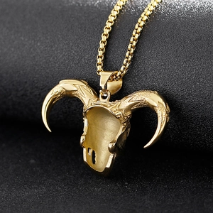 Macro detail of golden ram skull pendant with horns on a metal box chain necklace
