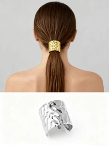 Detail of metallic C-shape ponytail hook featuring a textured hammered finish in gold and silver