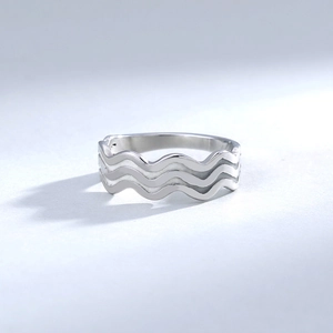 Macro shot of silver triple-layered wavy ring showing the polished stainless steel texture