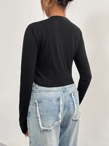 Eng anliegendes schwarzes Langarmshirt mit hellblauer High-Waist-Jeans in der Rückansicht