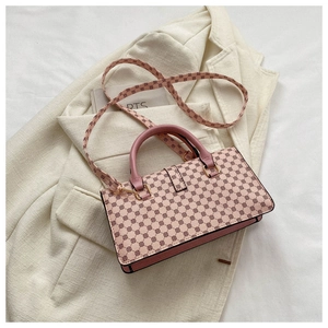 Pink lychee texture crossbody bag with geometric pattern on a cream suit jacket