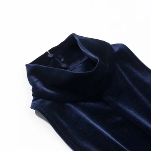 Detail of navy blue velvet dress featuring high collar and back neck button closure