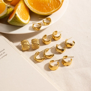 Detailed collection of irregular C-shaped 14K gold plated earrings on a linen background