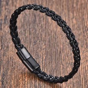 Makrodetail eines geflochtenen schwarzen Lederarmbands für Herren auf Holz