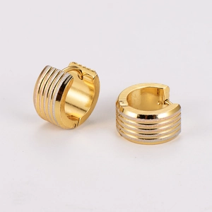 Detail of wide gold hoop earrings with silver ribbed texture and polished metal finish