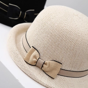 Close-up of beige sun hat with delicate wave-knit texture and elegant bow detail