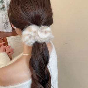 Dettaglio di un elastico per capelli in peluche a righe con morbida ecopelliccia