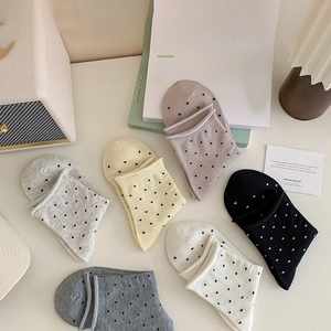 Détail de la couture invisible sur divers modèles de chaussettes en coton à pois