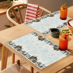 Detailed view of Christmas placemat featuring a winter snowy village scene on a wooden table