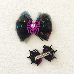 Detail of Halloween hair clips with spider web bow and purple glitter accents