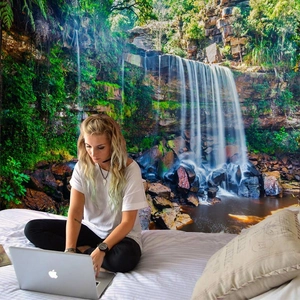 Detail showing forest waterfall tapestry as a decorative wall hanging in a cozy bedroom setup