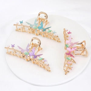 Detail of alloy butterfly hair claws with colorful enamel and white pearls set of three