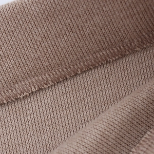 Detailed macro view of the brown knit fabric texture and high-quality edge stitching