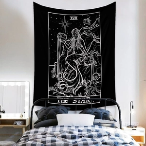 Detail of bohemian black and white The Star tarot tapestry hanging in a cozy bedroom