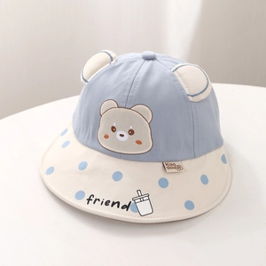 Détail d'un chapeau de soleil bébé avec oreilles d'ours et bord à pois bleus