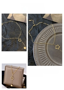 Detailed macro view of gold star tassel pendant necklace with long link chain