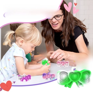 Detail of bow-shaped silicone pop-it fidget toy in bright pink and purple gradients