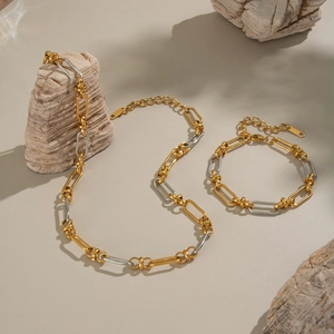 Two-tone gold and silver handmade chain necklace and bracelet set on stone decor