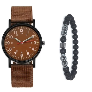 Close-up of minimalist quartz watch with brown nylon strap and matte black bead bracelet set