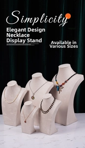 Five beige velvet neck bust displays for necklaces on marble table with green backdrop