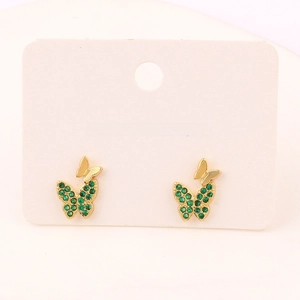Macro detail of butterfly stud earrings with green zircon stones on white display card