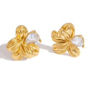 Close-up of golden flower stud earrings with pear-shaped cubic zirconia on white background