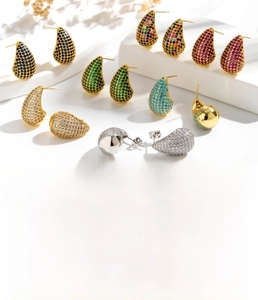 Détail macro de boucles d'oreilles goutte évidées avec zircons colorés