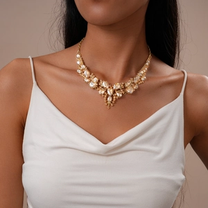 Close-up of elegant gold wedding necklace set with sparkling teardrop crystals on model