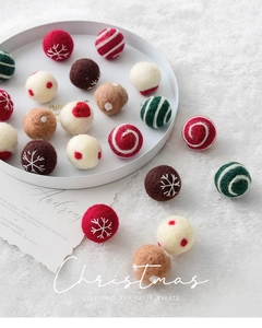 Detailed view of 3cm handmade wool felt balls with snowflake and heart embroidery