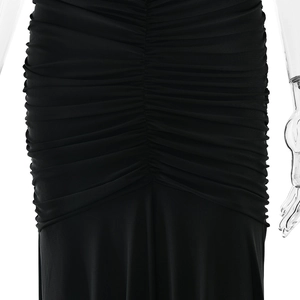 Close-up of gathered ruching details on black bodycon dress showing fabric texture