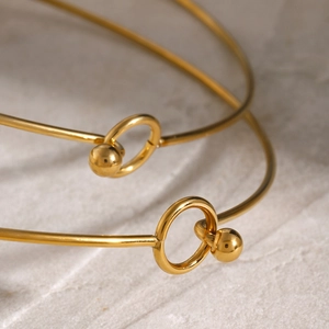 Elegant 18k gold plated stainless steel bangles set on a minimalist marble background
