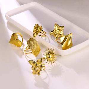 Set of 7 gold-toned adjustable rings featuring heart, butterfly, and leaf motifs with shadows