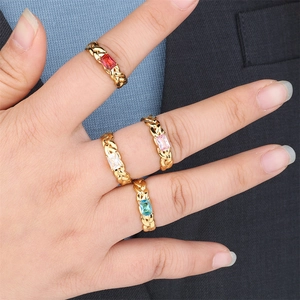 Detail of four gold-plated rope rings with rectangular colorful zircon gemstones