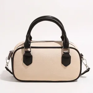 Two-tone Boston bag in cream fabric with black leather handles and silver hardware
