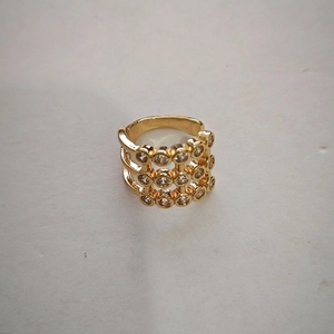 Detailed macro view of a gold wide three-layer ring set with white cubic zirconia stones