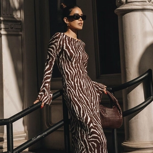 Detail shot of sheer zebra print maxi dress featuring elegant long flared sleeves and slim fit