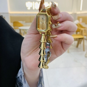 Dettaglio di un orologio da donna dorato rettangolare con cinturino in acciaio inossidabile