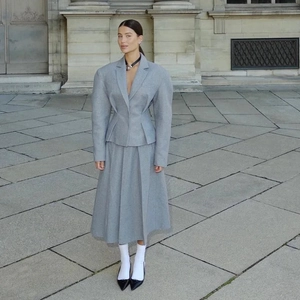 Détails des épaulettes structurées et de la taille ajustée d'un tailleur gris en laine