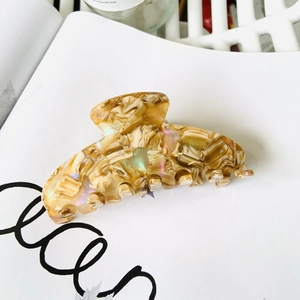Detailed view of large acetate hair claw clip with colorful marble pattern and pearly finish