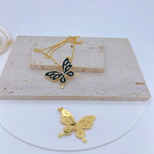 Detail of gold-plated butterfly pendant with black enamel and sparkling zircon accents