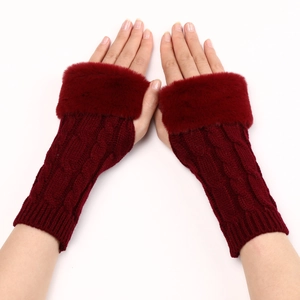 Detail of wine red cable knit fingerless gloves with plush faux fur trim on wrists