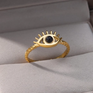 Macro shot of gold angel eye ring with black stone on gray velvet jewelry display box
