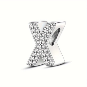 Detail of silver letter X bead charm with cubic zirconia pavé stones on white background