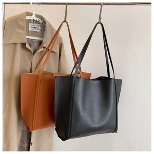 Detail of vintage tote bags in black and caramel brown leather with slender shoulder straps