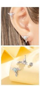 Detail of winged heart earrings with blue zircon stones and dangling arrow pendants
