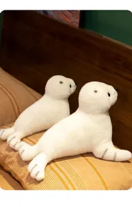 Gros plan de peluches de phoques blancs avec moustaches réalistes et texture douce en velours