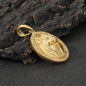 Détail macro du pendentif Anubis plaqué or avec strass étincelants et gravures en relief