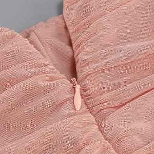 Detail view of pink mesh fabric with hidden zipper and fine stitching on a dress
