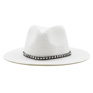Detail of white woven cowboy hat featuring black leather band and silver square studs