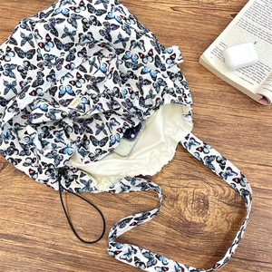 Detailed view of butterfly print tote bag with functional drawstring closure and inner lining